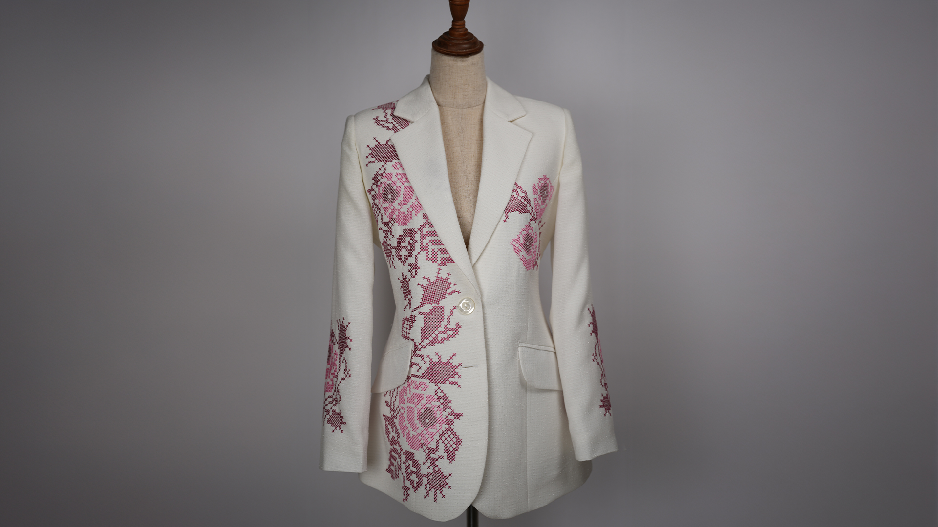 White blazer with pink cross-stitch floral embroidery on mannequin